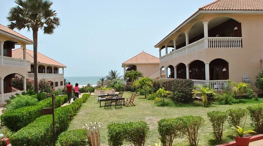 Lemon Creek Hotel's pink two-storey buildings and gardens leading toward the beach